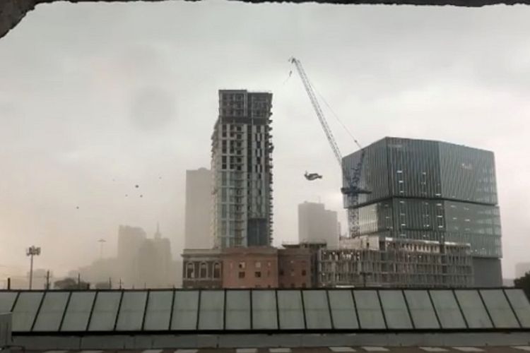 Sebuah crane konstruksi berayun-ayun sebelum akhirnya jatuh di teroa angin kencang di Dallas, Texas, AS, Minggu (9/6/2019). (Carrie Smith via REUTERS)