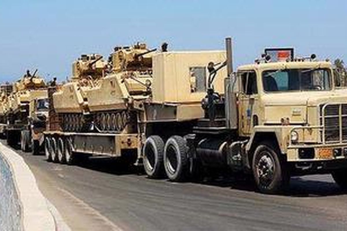 Sejumlah truk tentara mengangkut tank-tank militer Mesir di Semenanjung Sinai bagian utara.  