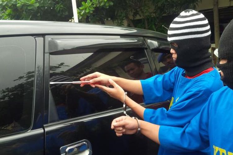  Tersangka Eko dan Budi memeragakan cara mencongkel karet kaca mobil menggunakan obeng sebelum memecah kacanya di Polres Semarang. 