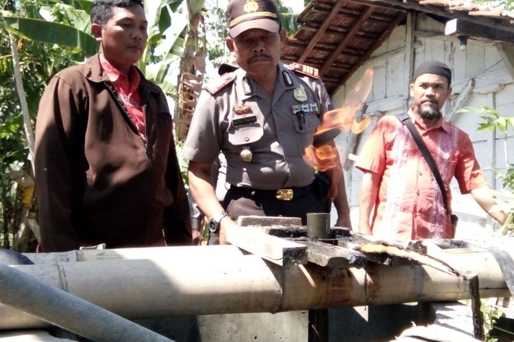 Kapolsek Guntur , AKP Ketut Patra bersama warga saat mengecek semburan gas di sumur milik Dwi Widodo di Desa Pamongan,  Kecamatan Guntur,  Kabupaten Demak,  Jateng,  Selasa (25/7/2017)