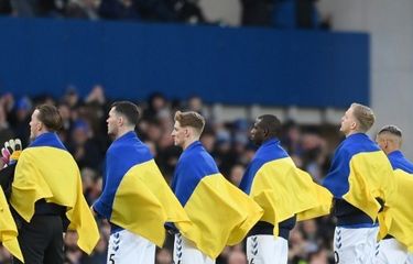 Para pemain Everton membawa bendera Ukraina ketika memasuki lapangan pada pertandingan pekan ke-27 Liga Inggris kontra Manchester City yang dihelat di Stadion Goodison Park, Minggu (27/2/2022).