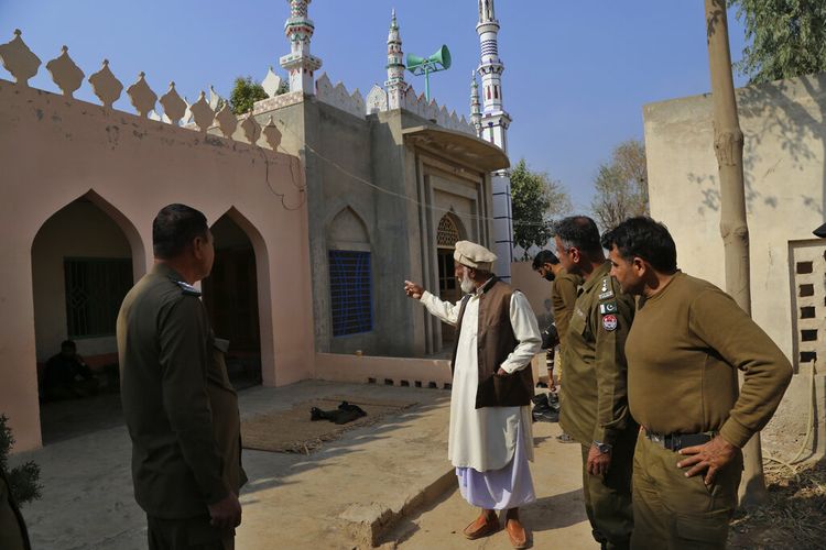 Mian Mohammad Ramzan, tengah, penjaga masjid, memberi isyarat saat dia memberi pengarahan kepada petugas polisi mengenai rajam sampai mati terhadap Mushtaq Ahmed, 41, oleh massa yang marah karena diduga menodai Alquran, di sebuah masjid, di Tulamba, sebuah desa terpencil di distrik tersebut. dari Khanewal di Pakistan timur, Minggu, 13 Februari 2022. 