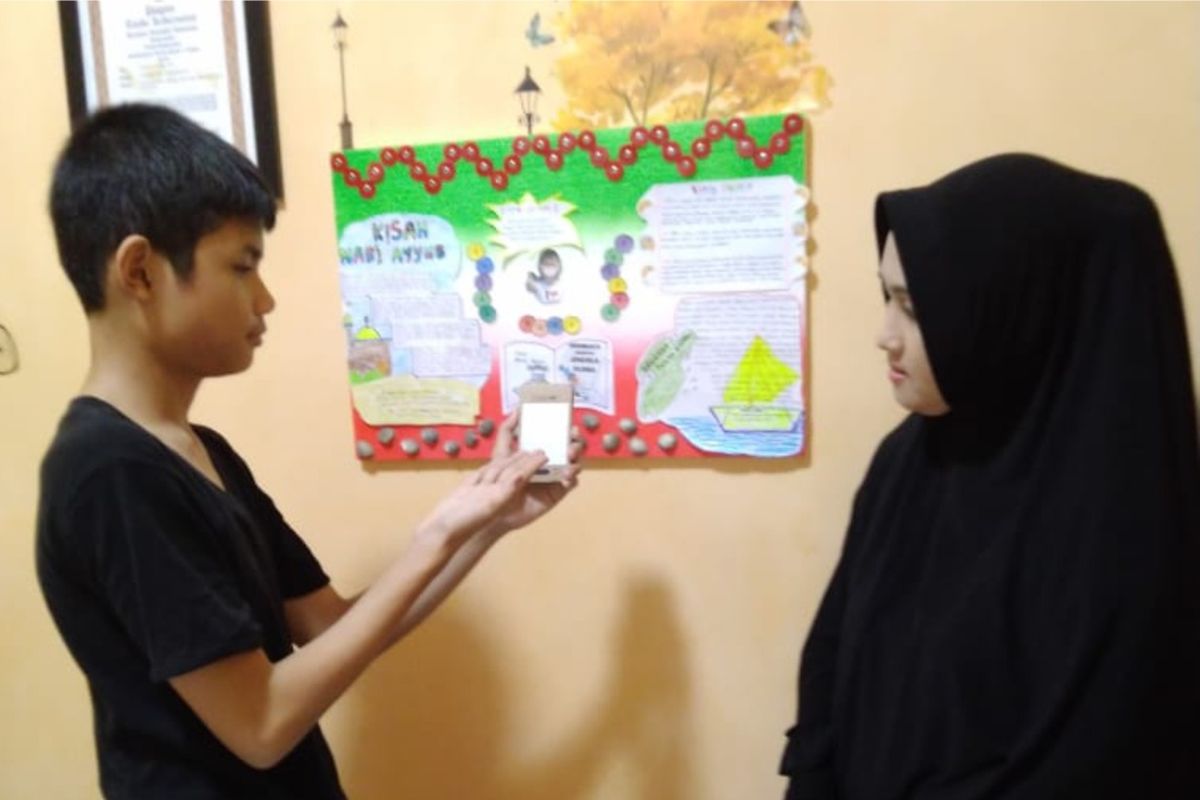 Ihsan Budi Sastra, siswa kelas VI MI Muhammadiyah 1 Pekanbaru Riau, mempresentasikan hasil bacaan dipajang di mading kepada orangtuanya