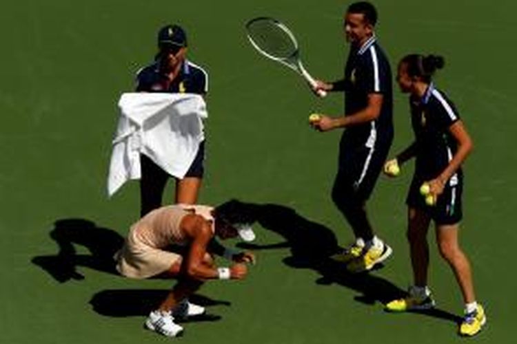 Petenis Jepang, Kimiko Date-Krumm (tengah) menunduk untuk menghindari lebah yang mengganggunya ketika bertanding melawan Venus Williams (AS) pada babak pertama AS Terbuka di Billie Jean King National Tennis Center, New York, Senin (25/8/2014). Para ball kid mencoba mengusir lebah tersebut.