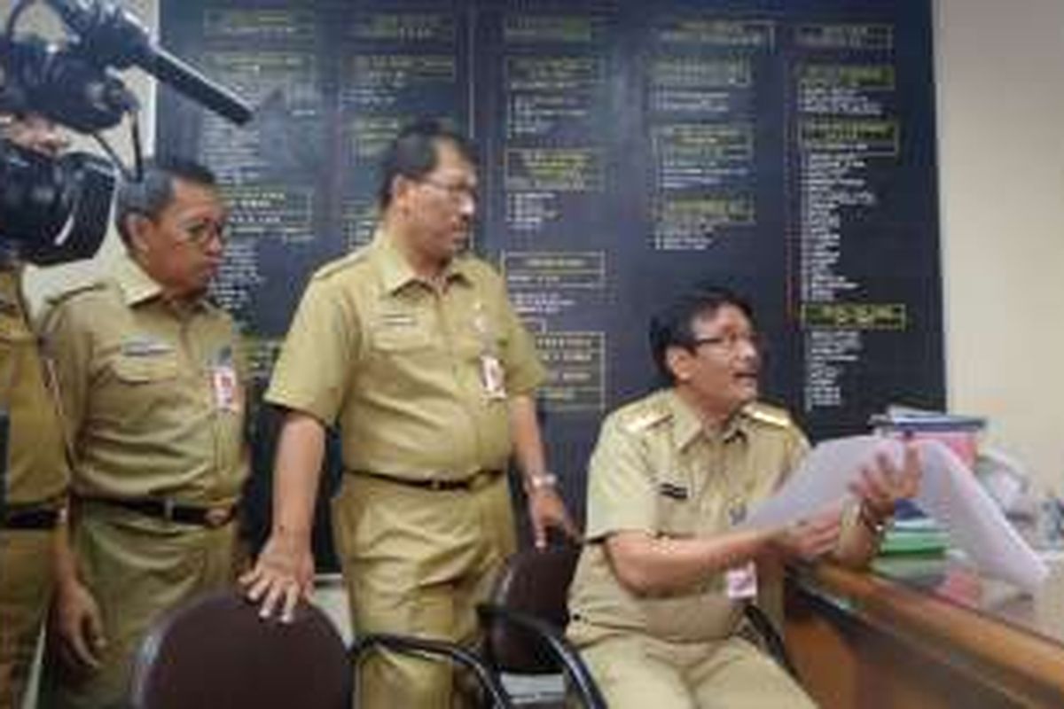 Wakil Gubernur DKI Jakarta Djarot Syaiful Hidayat memeriksa daftar kehadiran PNS DKI di ruang Bagian Umum Kesekretariatan Dewan, Senin (11/7/2016). 