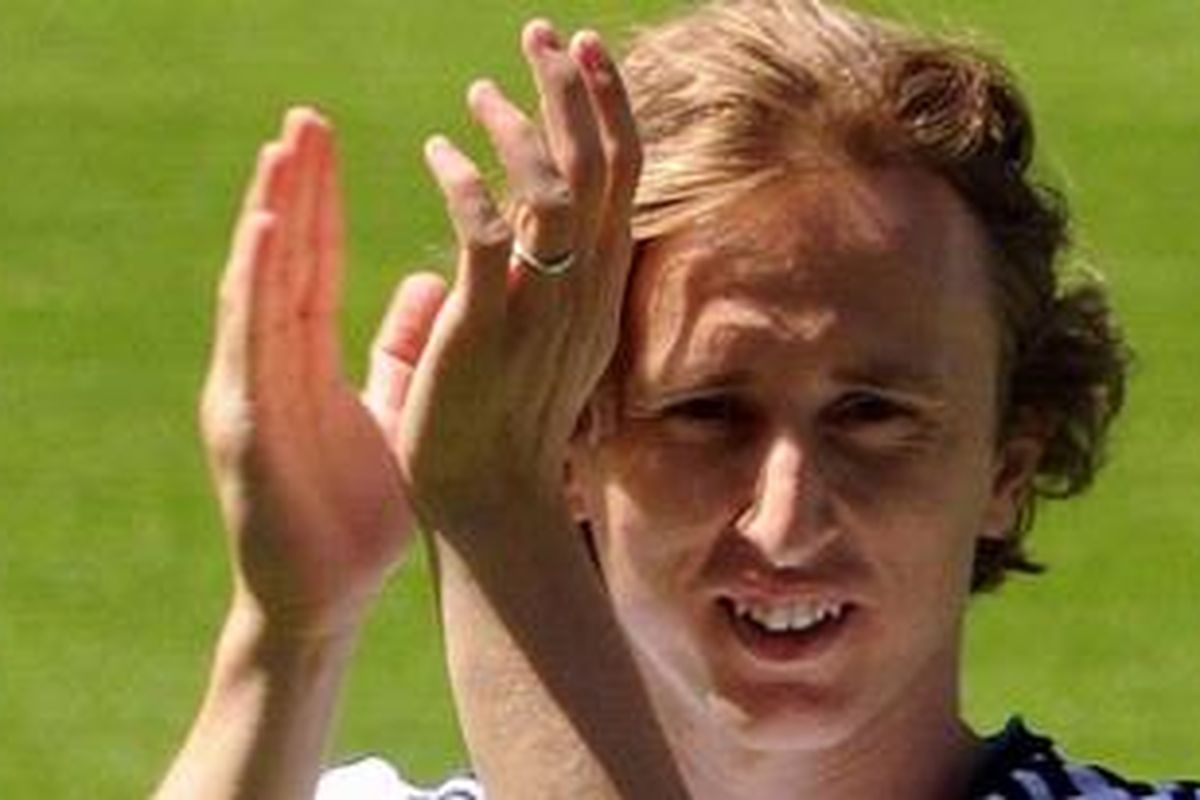 Pemain anyar Real Madrid dari Kroasia, Luka Modric, bertepuk tangan membalas sambutan fans saat resmi dipresentasikan di Stadion Santiago Bernabeu, Senin (27/8/2012). 