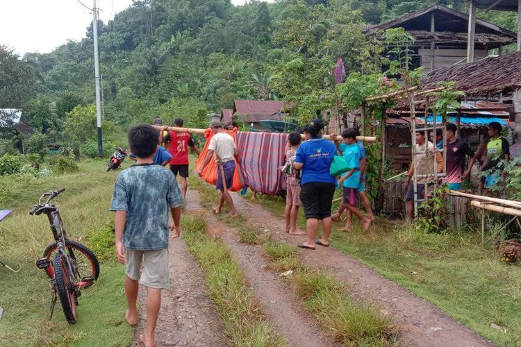 Seorang warga di Mamuju terpaksa ditandu warga saat hendak berobat usai akses jalan rusak berat di Desa Kinatang, Kecamatan Bonehau, Mamuju, Selasa (4/10/2022).