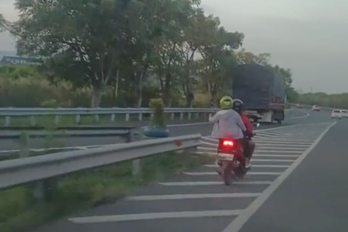 Tangakapan video pemotor yang masuk dalam area jalan tol menuju Gresik, Gerbang Tol Romokalisari, Jawa Timur, Minggu (21/5/2023).