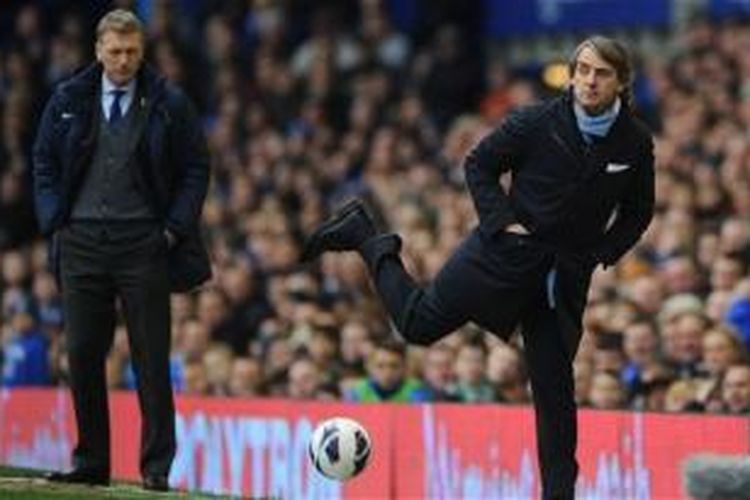 Pelatih Manchester United, David Moyes (kiri) dan Roberto Mancini. 