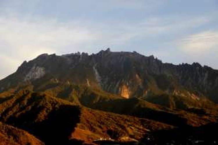 Sinar matahari pagi menyelimuti Gunung Kinabalu dilihat dari Kundasang, Ranau, Sabah, Malaysia, Senin (21/11/2016). Gunung Kinabalu dipercaya masyarakat Kandazan Dusun sebagai tempat tinggal roh-roh setelah mati sebelum pergi ke surga.