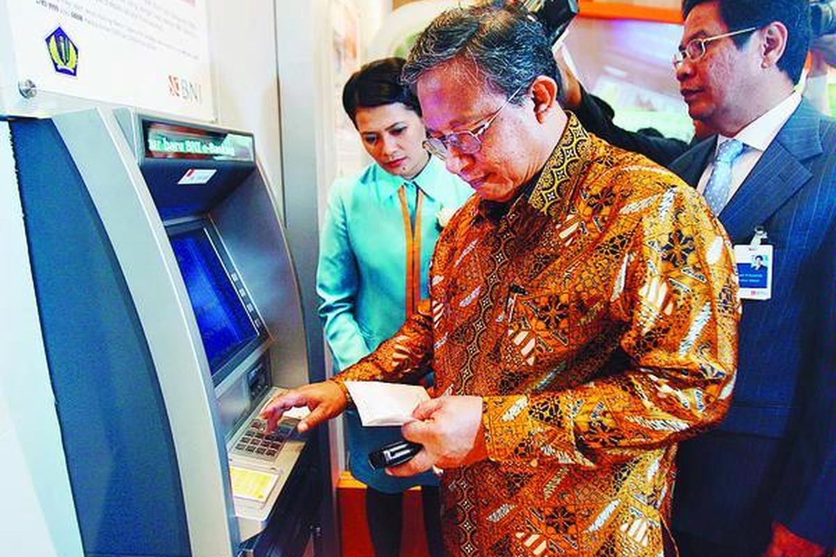 Dirjen Pajak Darmin Nasution melakukan simulasi pembayaran pajak melalui ATM di Gedung Departemen Keuangan Jakarta, Selasa (15/6), seusai menandatangani kerja sama pembayaran pajak secara elektronik dengan Direktur Utama BNI Gatot M Suwondo (kanan).  