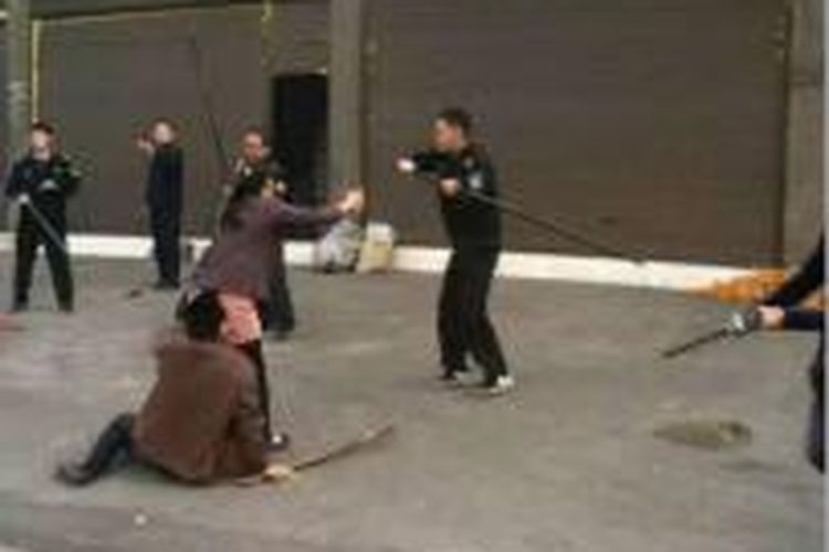 Foto kontroversial Inspektur Lalu Lintas di Yunnan Tiongkok memukuli pengendara yang bandel dengan tongkat panjang 