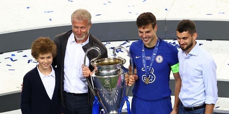 Pemilik Chelsea Roman Abramovich tersenyum saat mengangkat trofi Liga Champions bersama kapten Cesar Azpilicueta.