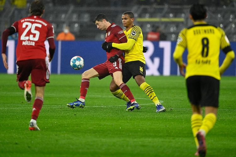 Penyerang Bayern Muenchen, Robert Lewandowski, berduel dengan bek Dortmund Manuel Akanji dalam laga Bundesliga 2021-2022 bertajuk Der Klassiker, 4 Desember 2021.