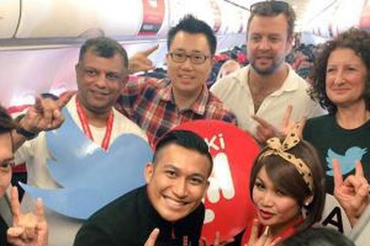 Tony Fernandes (memegang logo Twitter) bersama dengan kru AirAsia dan perwakilan roKKi dan Twitter dalam peresmian layanan akses Twitter dalam penerbangannya, Selasa (30/6/2015).
