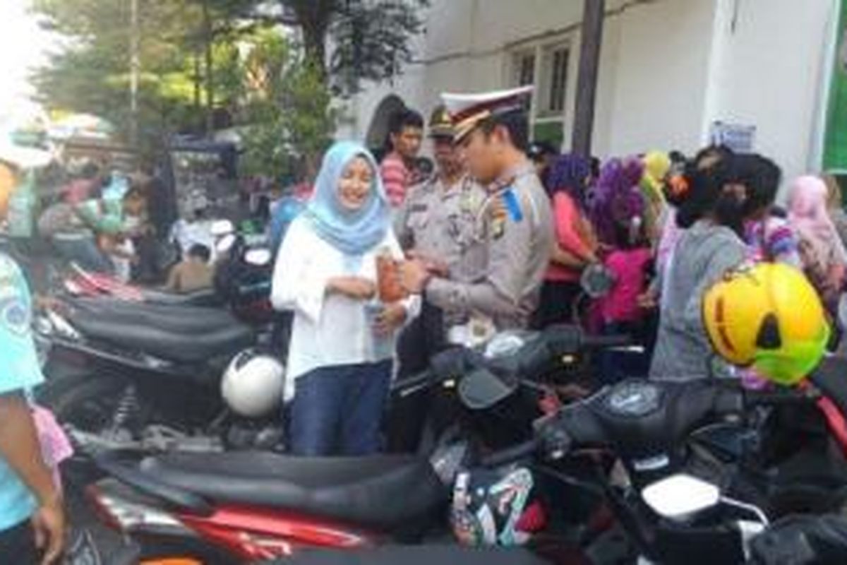 Anggota polisi berkeliling ke lokasi keramaian di wilayah Jakarta Barat untuk membagikan surat cinta kepada masyarakat, Rabu (22/7/2015). 