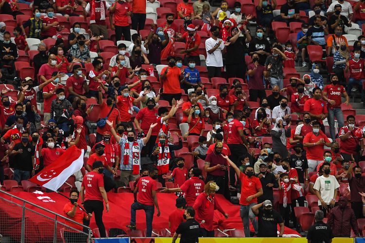 Suporter Timnas Singapura bersorak memberi dukungan timnya pada pertandingan leg kedua semifinal Piala AFF 2020 antara Singapura vs Indonesia di National Stadium, Singapura, Sabtu (25/12/2021). Timnas Indonesia dipastikan melaju ke final Piala AFF 2020 setelah menumbangkan Singapura 4-2 pada laga semifinal kedua.