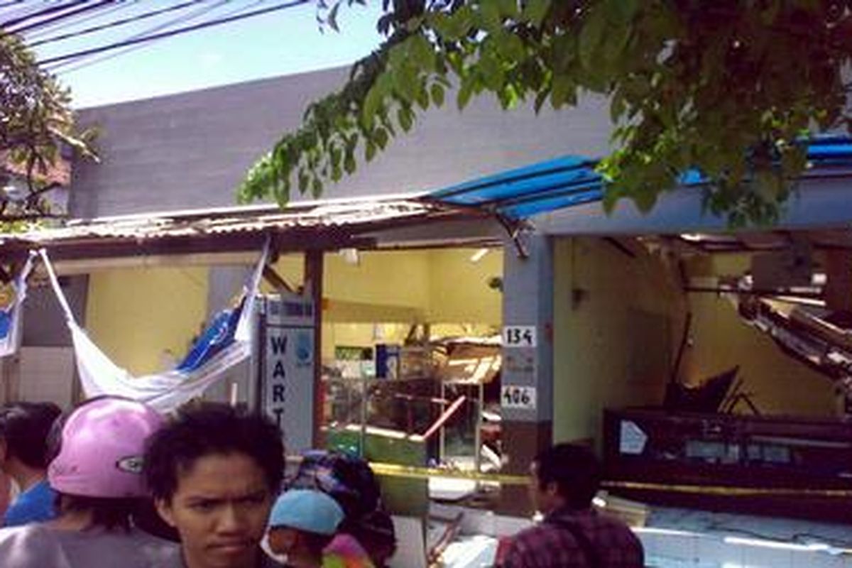 Warga tengah menonton 2 buah toko yang hancur akibat ledakan yang diduga berasal dari tabung gas