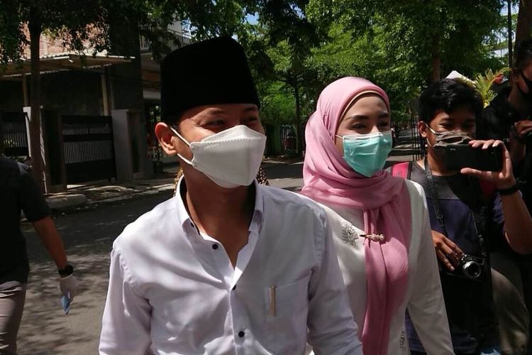 Calon Bupati Petahana Mochammad Nur Arifin bersama istri yakni Novita Hardini, berjalan menuju TPS 3 Surodakan Trenggalek Jawa Timur, hendak menyalurkan hak suaranya, Rabu (09/12/2020).