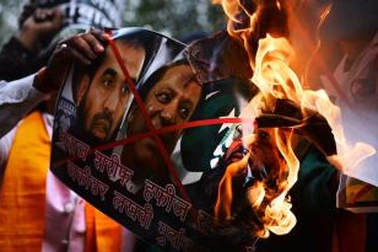Warga India membakar foto terdakwa dalang aksi teror Mumbai Zaki-ur-Rehman Lakhvi yang dibebaskan pengadilan Pakistan pada Kamis (18/12/2014).