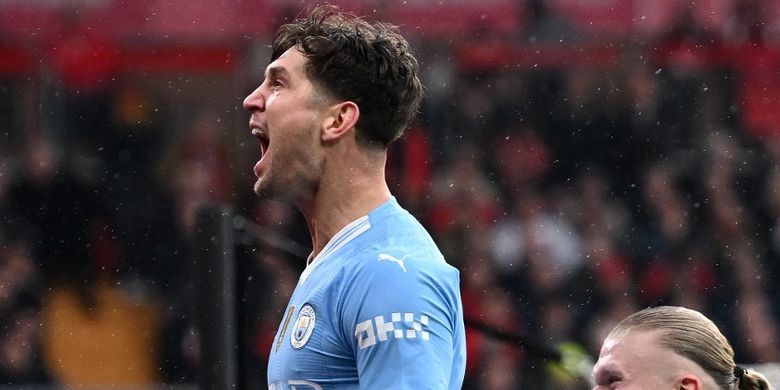 Pemain Man City, John Stones, merayakan gol pertama pada laga Liverpool vs Man City di ajang lanjutan Liga Inggris di Stadion Anfield, Minggu (10/3/2024).