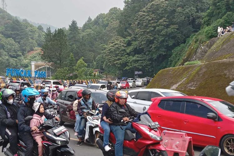 Kepadatan kendaraan di kawasan Puncak Pass Cianjur, Jawa Barat, Minggu (30/4/2023) siang. Petugas tengah memberlakukan one way dari arah Bogor menuju Puncak