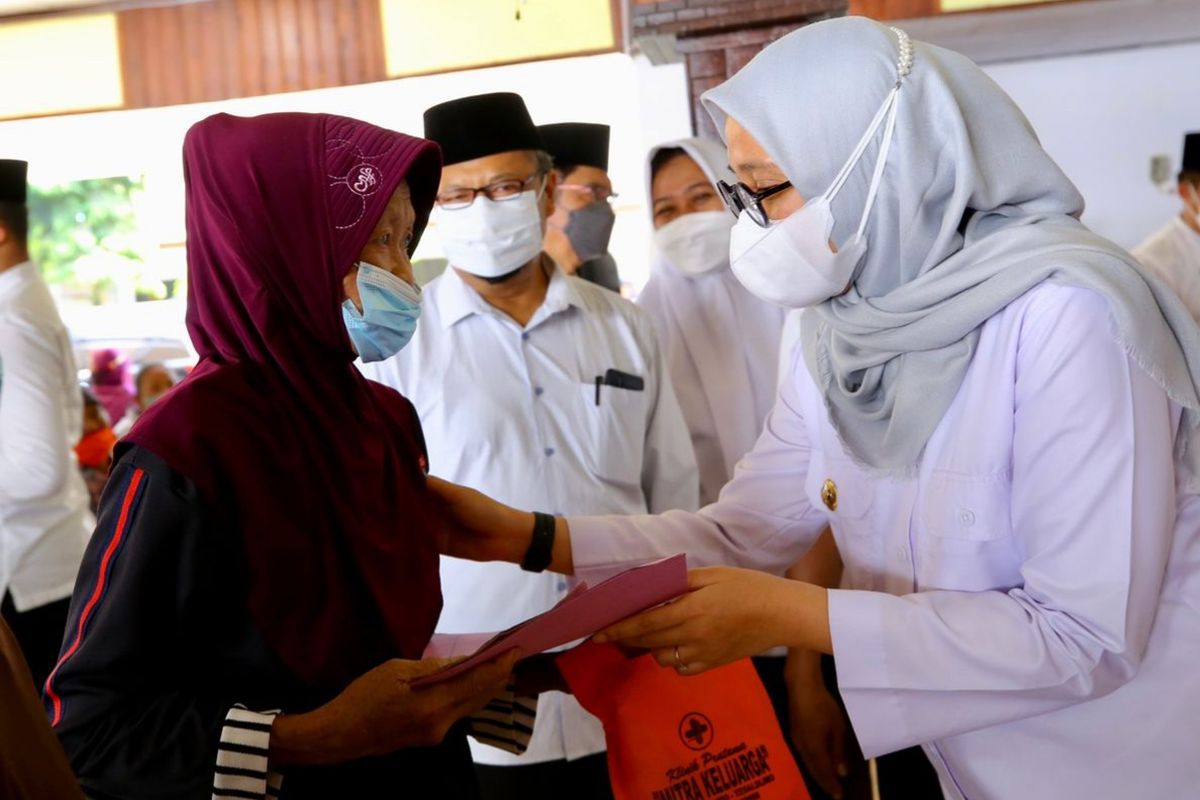 Bupati Banyuwangi Ipuk Fiestiandani menyerahkan BLT minyak goreng kepada seorang warga penerima di Kecamatan Purwoharjo, Kamis (14/4/2022).