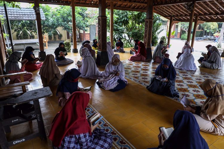 Santri putri mengaji di Pondok Pesantren An Nuqthah, Kota Tangerang, Banten, Kamis (18/6/2020). Pondok pesantren An Nuqthah kembali melaksanakan aktivitas setelah libur panjang akibat COVID-19 dengan menerapkan protokol kesehatan dan pengecekan kesehatan bagi santri yang baru tiba.