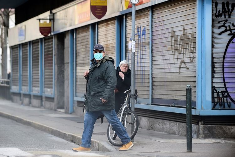 Seorang pria dengan masker pelindung berjalan di pasar Madama Cristina, yang sepi setelah pemerintah Italia melaksanakan penutupan daerah besar di utara Italia, di Turin, Italia, Senin (9/3/2020). ANTARA FOTO/REUTERS/Massimo Pinca/nz/cfo