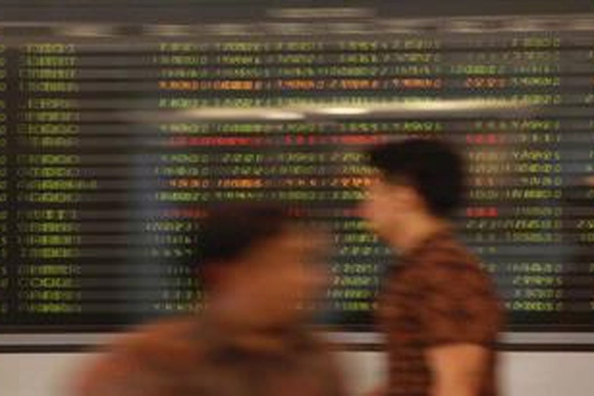 Pengunjung melintas di dekat papan indeks harga saham gabungan (IHSG) di Mandiri Sekuritas, Jakarta, Jumat (13/4/2012). Indeks Harga Saham Gabungan (IHSG) ditutup menguat 19 poin atau 0,47 persen menjadi  4.159,27.
