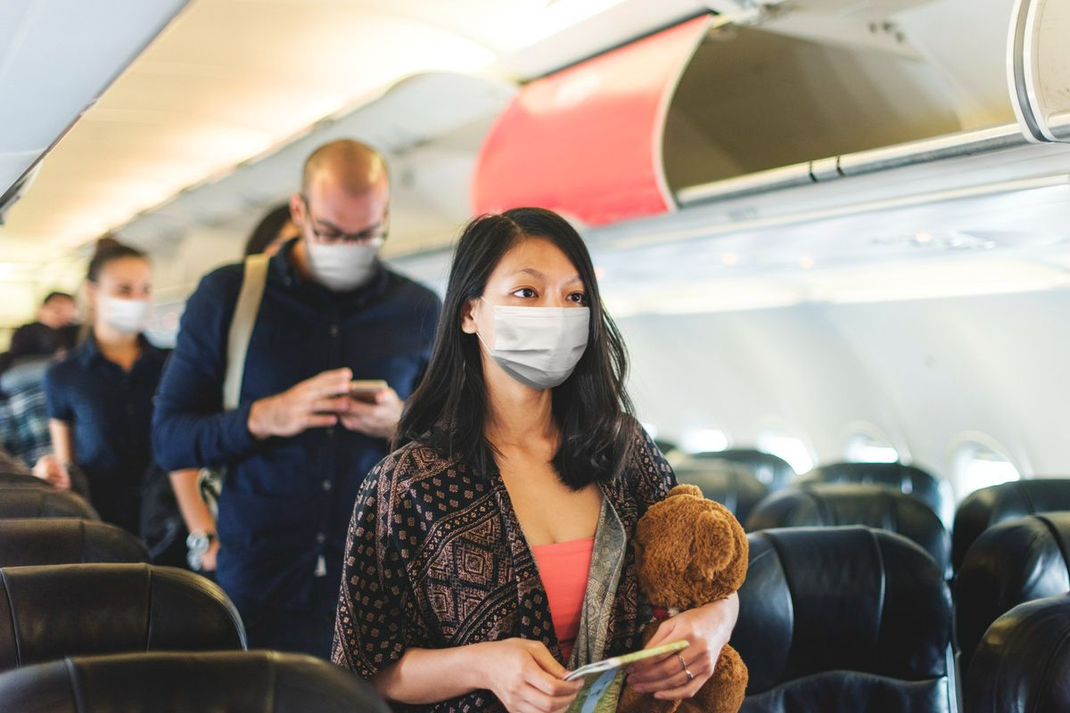 Ilustrasi penumpang pesawat mengenakan masker.