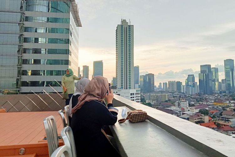 Pengunjung kafe rooftop Kuningan City Mall duduk sembari melihat pemandangan dari ketinggian.