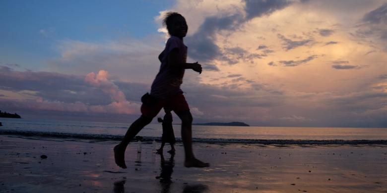 Anak-anak Desa Barawai bermain di pantai saat matahari mulai tenggelam. 