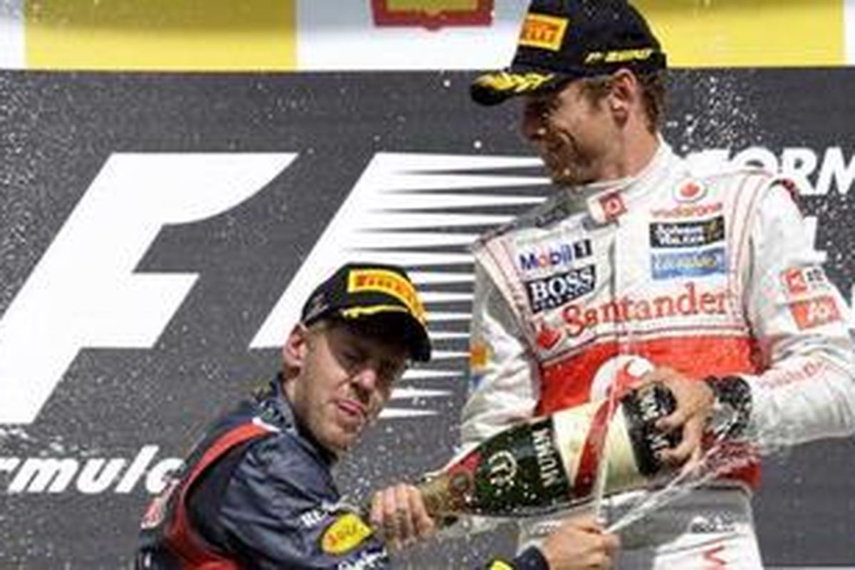 Pebalap McLaren, Jenson Button (kanan), bersama pebalap Red Bull Racing, Sebastian Vettel, usai lomba di Belgia, Minggu (2/9/2012). Button jadi pemenang dan Vettel runner-up.