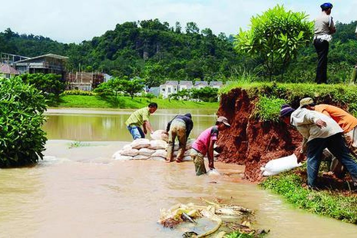 Sejumlah pekerja, Sabtu (26/1), mulai memperbaiki tanggul danau buatan di Perumahan Citra Garden, Bandar Lampung,  Lampung, yang jebol akibat banjir pada Kamis lalu. Luapan air mengakibatkan ratusan rumah di Kelurahan Teluk Betung Barat terendam banjir selama tiga hari terakhir.