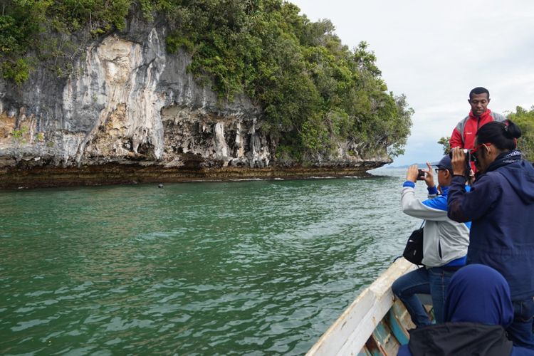 Pengunjung mengambil gambar kerangka manusia yang diletakkan di tebing karang di Distrik Kokas Fakfak Papua Barat