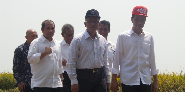 Presiden Joko Widodo (Jokowi) mengenakan topi snap cap berlogo  62 saat blusukan ke Karawang, Jawa Barat, Minggu (27/9/2015).