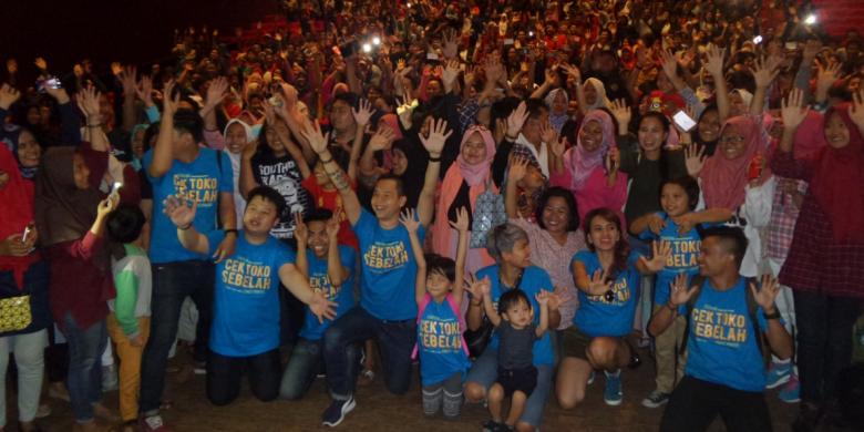 Ernest Prakasa (mengenakan t-shirt biru muda, di tengah depan, mengangkat kedua tangan) bersama mereka yang juga ambil bagian dalam acara menonton bareng film Cek Toko Sebelah di Mega Bekasi XXI, Jawa Barat, pada Minggu (1/1/2017) sore.
