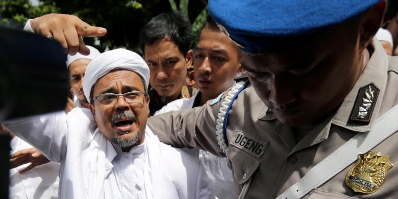 Pimpinan Front Pembela Islam, Rizieq Shihab tiba di Kantor Direktorat Reserse Kriminal Khusus, Polda Metro Jaya, Jakarta, Senin (23/1/2017). Rizieq diperiksa oleh Subdirekorat Fiskal, Moneter, dan Devisa Direktorat Reserse Kriminal Khusus Polda Metro Jaya, terkait ucapannya soal gambar palu arit di logo Bank Indonesia dalam lembaran uang rupiah. KOMPAS IMAGES/KRISTIANTO PURNOMO