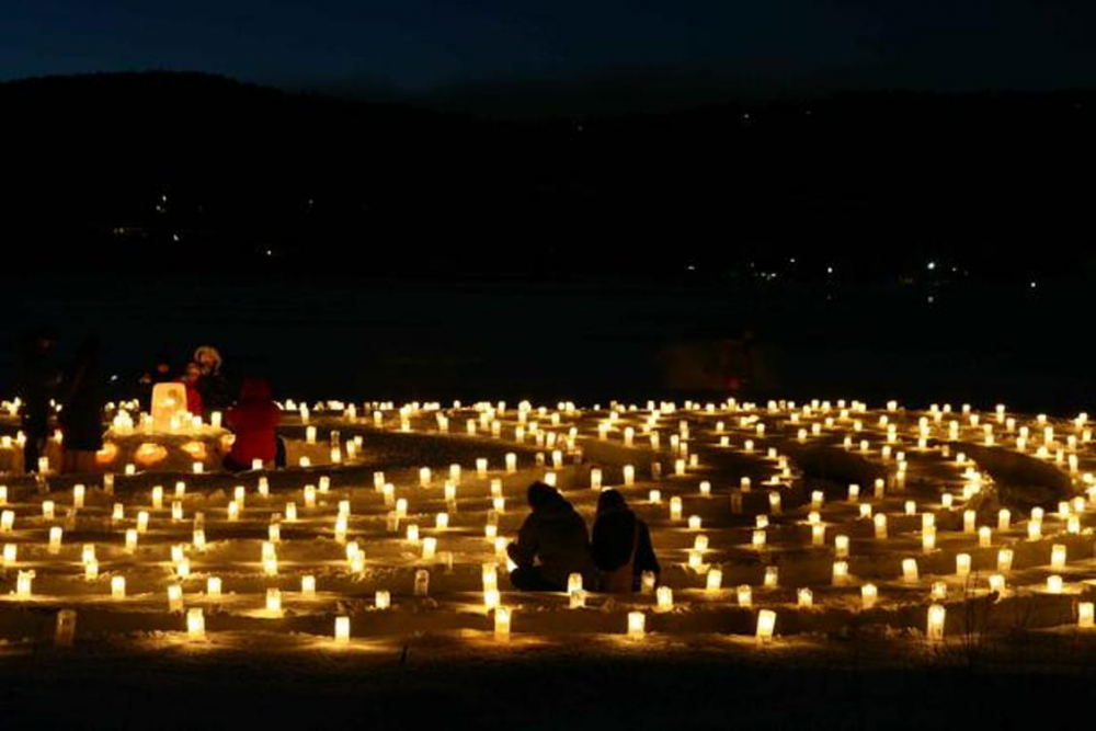 Suasana romantis dari ice candle yang menyala di pinggiran danau