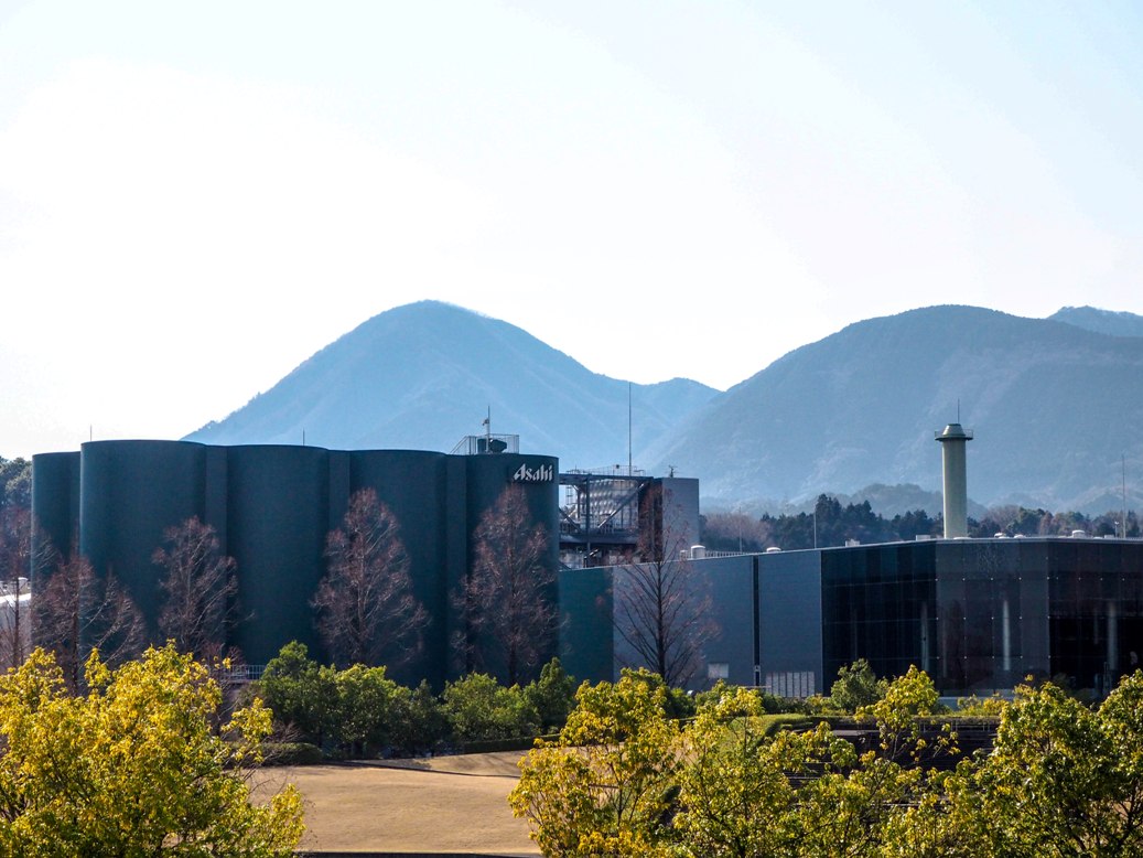Pabrik bir Asahi dikelilingi oleh alam 