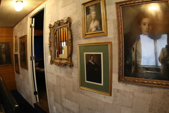 Koridor yang dihiasi oleh foto-foto dan lukisan tua.