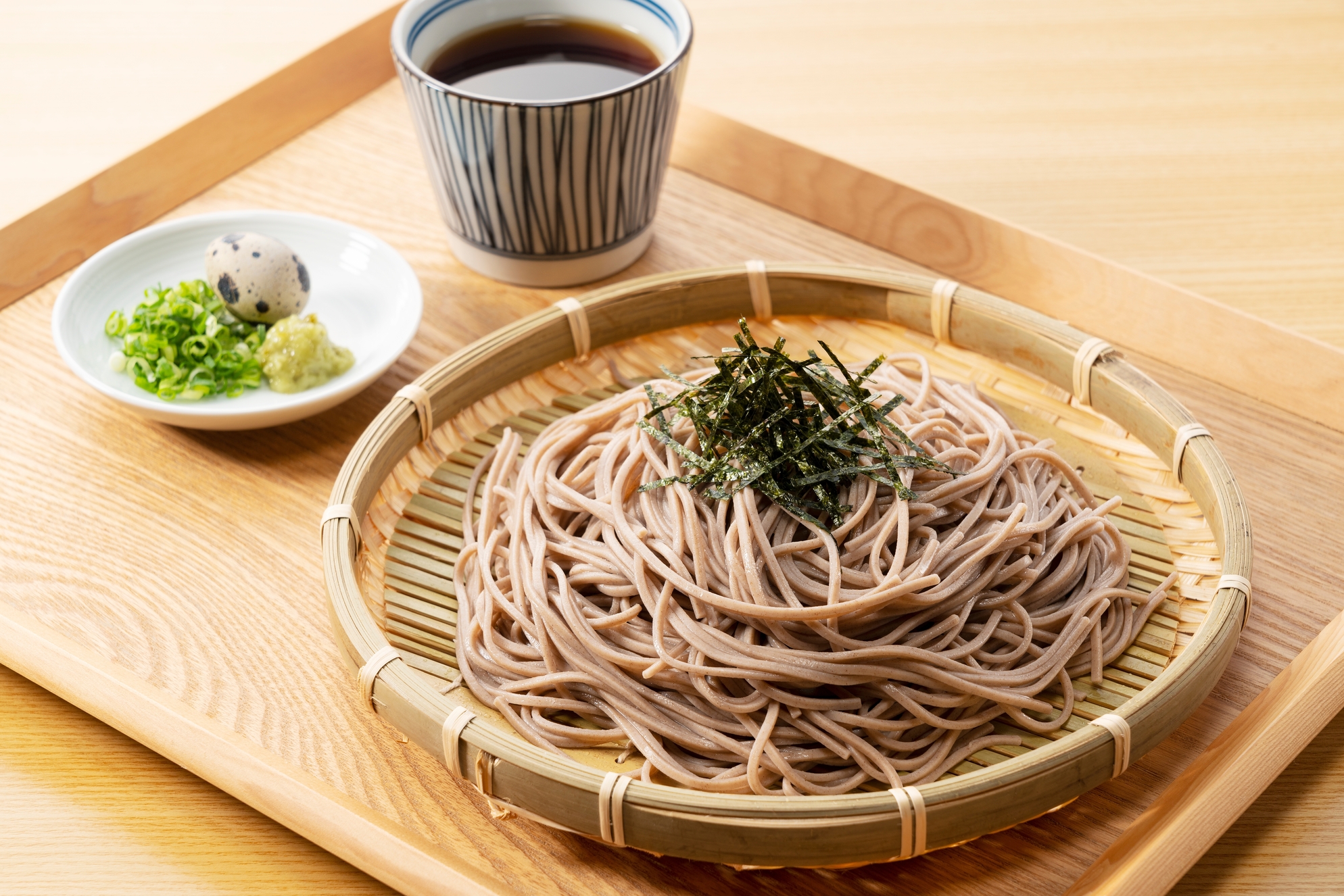 Zaru-soba and condiments on a wooden table. Zaru soba is a traditional Japanese food.