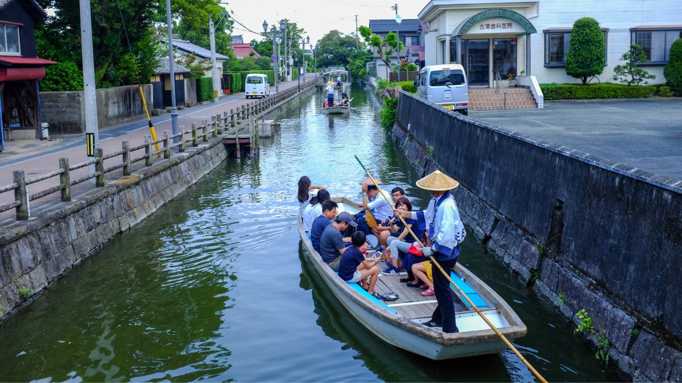 Pengunjung sedang menyusuri sungai Yanagawa, Jepang.