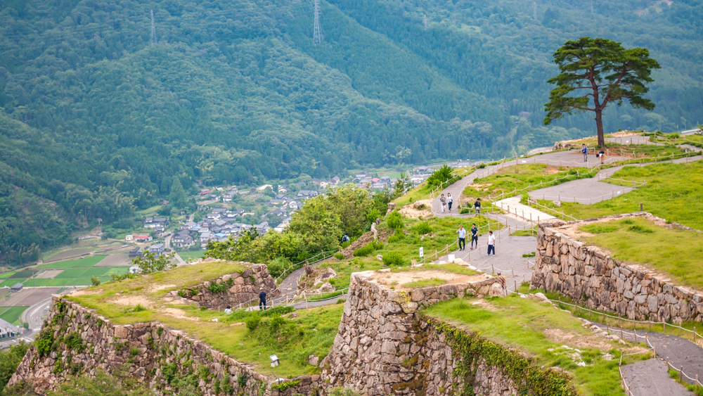 Landscape photo of tourists and local visitors walking around Takeda Castle Ruins located in Hyogo Prefectures Asago City in Japan, which is a famous and popular side trip from nearby Himeji.