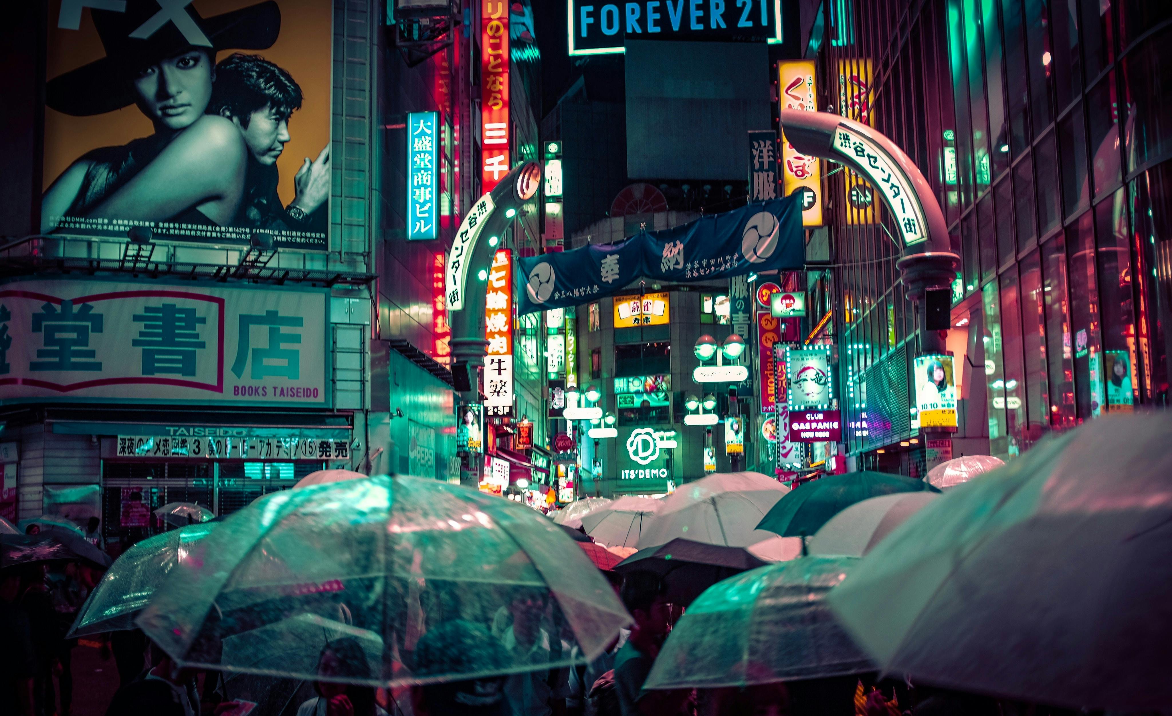 Suasana Shibuya saat hujan turun, banyak orang menggunakan payung.
