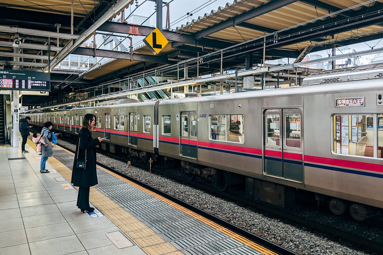 Ilustrasi pekerja di Jepang menunggu kereta di stasiun. 