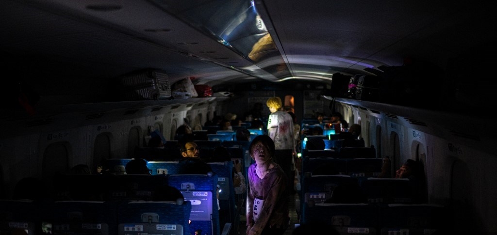 Aktor berperan sebagai zombi menakuti penumpang shinkansen dari Tokyo ke Osaka dalam rangka menyambut Halloween, (19/10/2024). (AFP/PHILIP FONG)