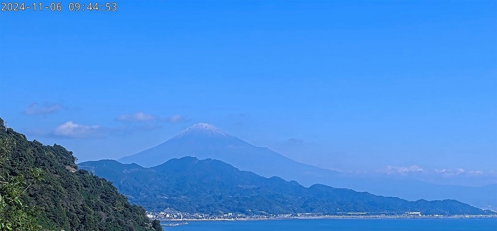 Tangkapan layar ini diambil dari siaran video langsung yang disiarkan oleh Pemerintah Kota Shizuoka pada 6 November 2024 yang memperlihatkan Gunung Fuji (belakang kiri) dengan lapisan salju di puncaknya, terlihat dari sisi Kota Shizuoka di gunung tersebut. Salju akhirnya turun di Gunung Fuji, foto-foto yang dibagikan oleh pemerintah daerah dan penduduk setempat menunjukkan pada 6 November 2024, setelah gunung Jepang itu mengalami masa terlama dengan lereng yang gundul.