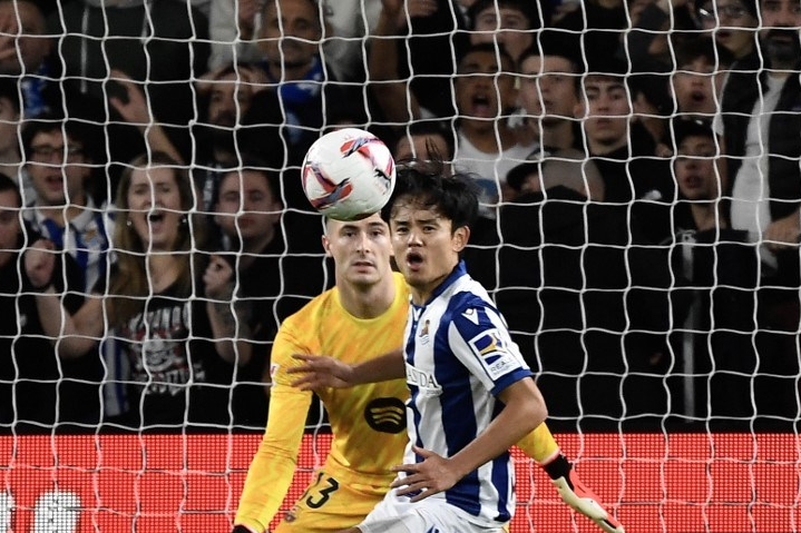 Kiper Barcelona asal Spanyol Inaki Pena menjaga gawang dari penyerang Real Sociedad asal Jepang Kubo Takefusa selama pertandingan sepak bola liga Spanyol antara Real Sociedad dan FC Barcelona di stadion Anoeta di San Sebastian pada 10 November 2024.